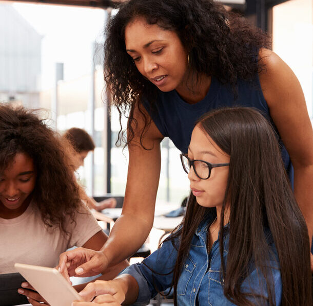 Special needs student getting help from her teacher.